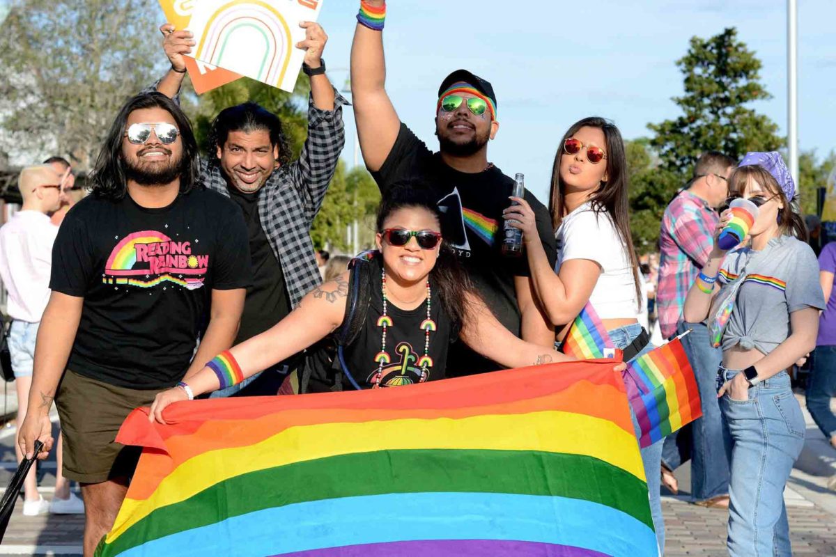 Group at PRIDE 2020 holding LGBTQ+ rainbow flag